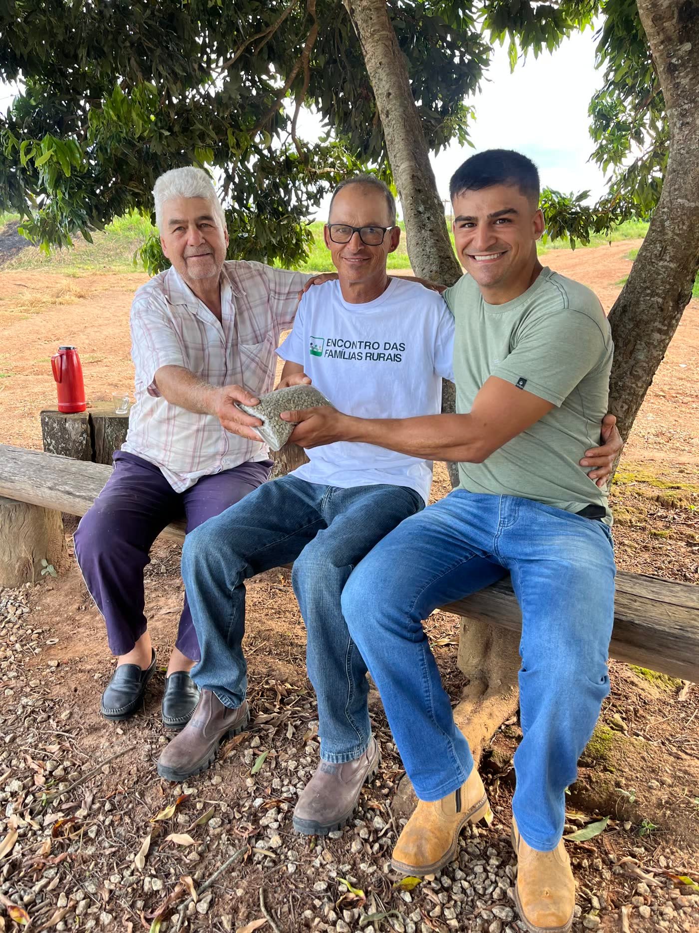 Três gerações da família da Fazenda Goiabas segurando café verde